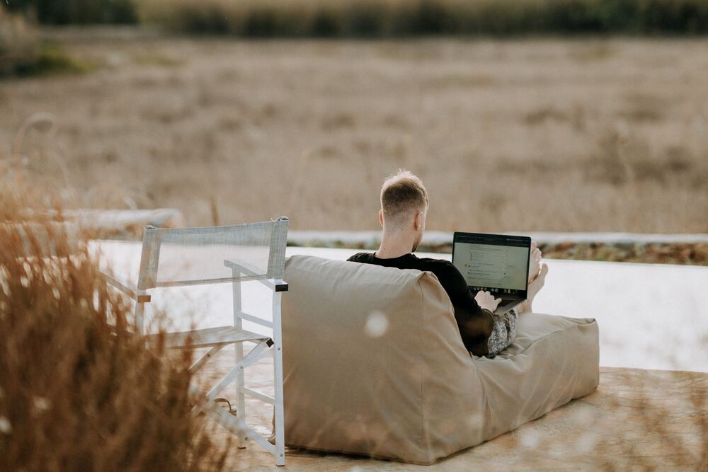 homem em ambiente de trabalho externo mexendo no notebook representando como ter internet em qualquer lugar