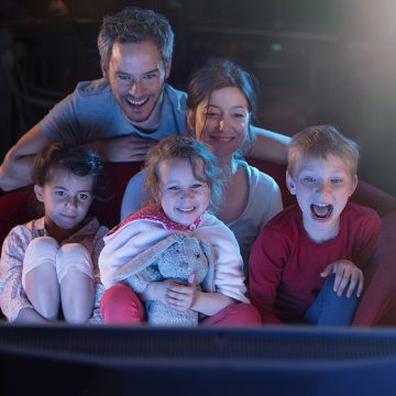 Família reunida em frente a TV para conferir filmes e séries de Natal