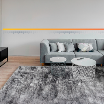 Imagem ilustrativa de uma sala de estar clean mostrando a distância ideal entre a TV e sofá