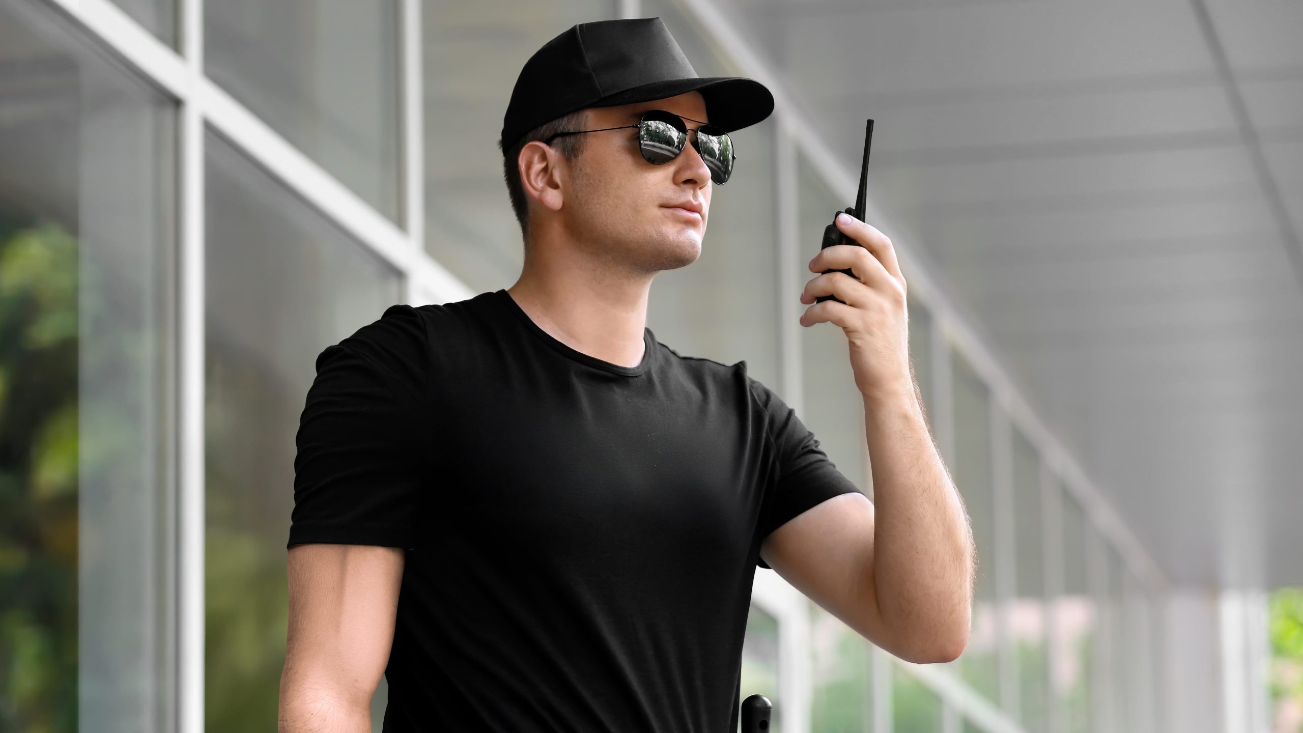 homem segurança segurando um rádio comunicador walk talk